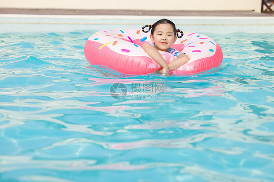 小女孩趴在游泳圈上开心戏水图片