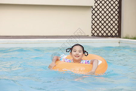 小女孩趴在游泳圈上游泳图片