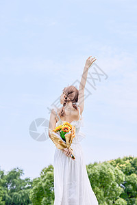 手拿鲜花的女生手拿鲜花的夏日美女背影背景