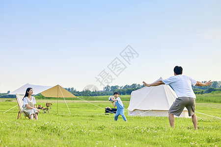 足球草坪爸爸带着孩子草坪踢足球背景