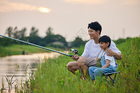 年轻爸爸带着儿子户外钓鱼背景图片