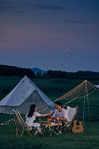 情侣野餐年轻情侣夜晚户外野营背景