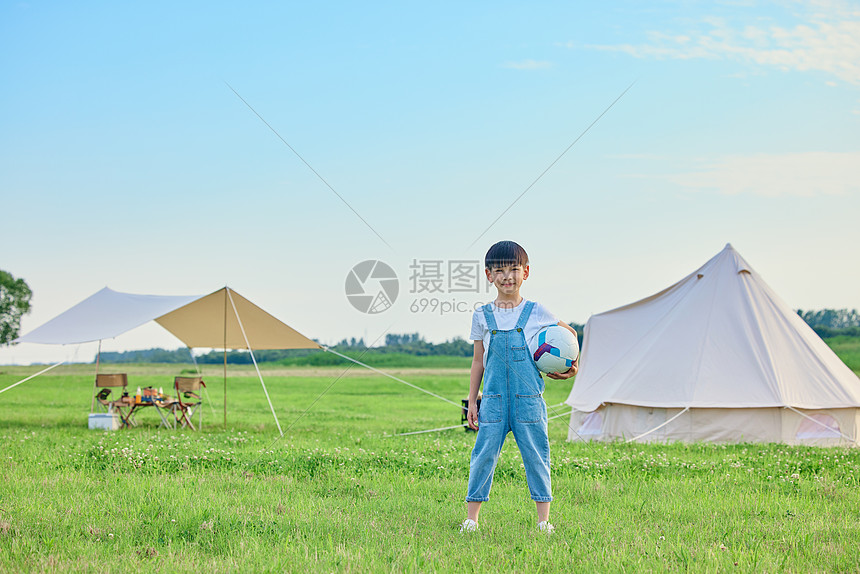 小男孩户外草坪上抱着足球图片