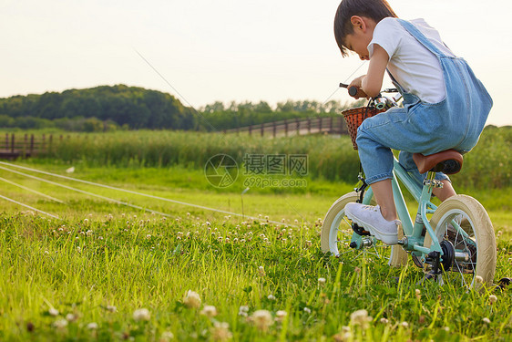 小男孩户外草坪上骑自行车图片