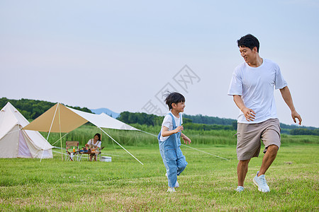 小男孩和爸爸在草坪上追逐打闹背景