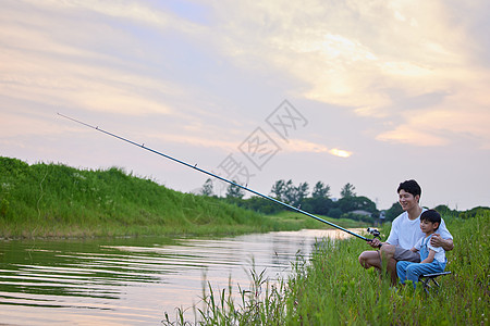年轻爸爸带着儿子户外钓鱼图片