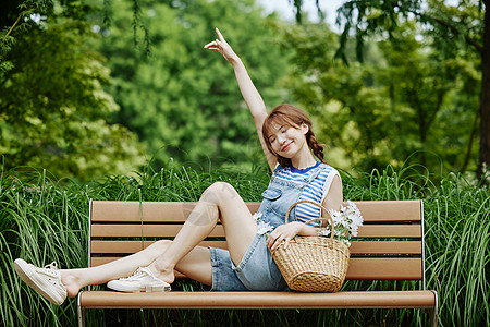 绿色小清新主图坐在长椅上搞怪的夏日美女背景