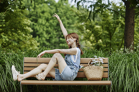 坐在长椅上的夏日美女图片