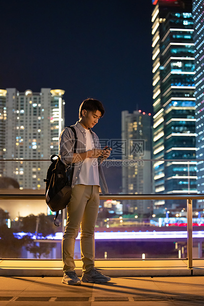 夜晚在城市走路的男性图片