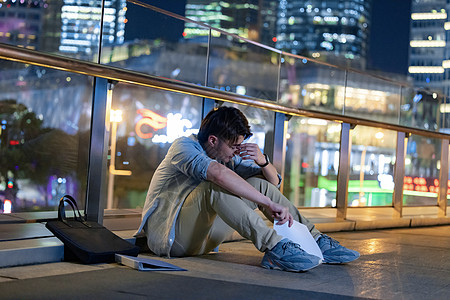 坐在路边悲伤难过的男性青年图片