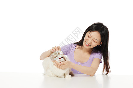 青年女性给宠物猫梳毛图片