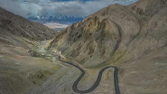 航拍5A帕米尔高原旅游景区著名景点山脉了穿行的盘龙古道背景图片