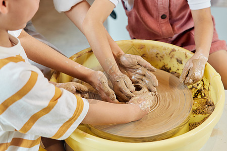 陶艺老师辅助小朋友制作陶艺品高清图片