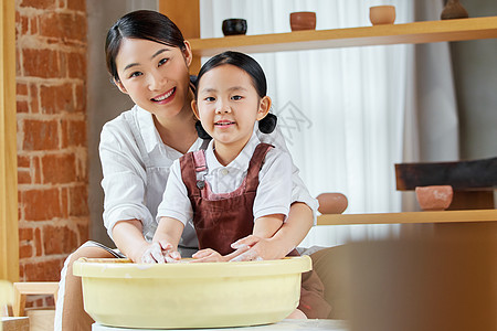 指导培训美女老师教小女孩制作陶艺作品背景