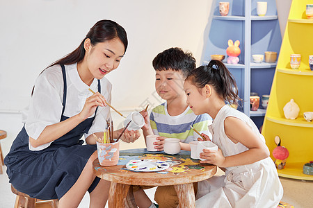亲子陶艺艺术老师教小朋友陶罐作画背景