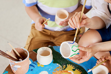 快乐儿童艺术字老师教小朋友陶罐作画特写背景