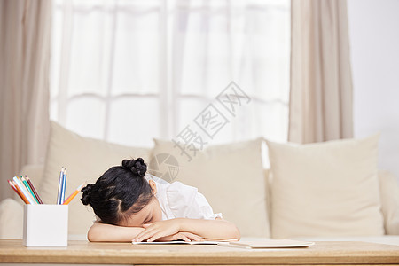 小女孩在家做作业疲惫睡着图片