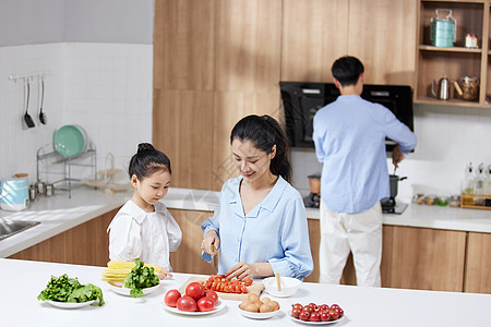 温馨一家三口在厨房做饭图片素材