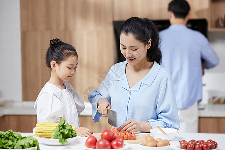 一家三口在厨房母亲在家里教女儿做饭背景