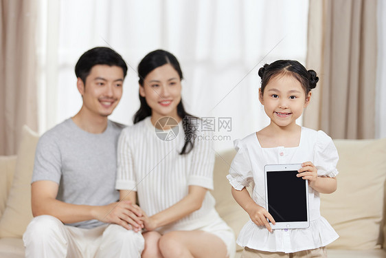 小女孩在家里拿着平板电脑展示图片