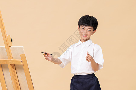 站在画板前绘画的小男孩图片