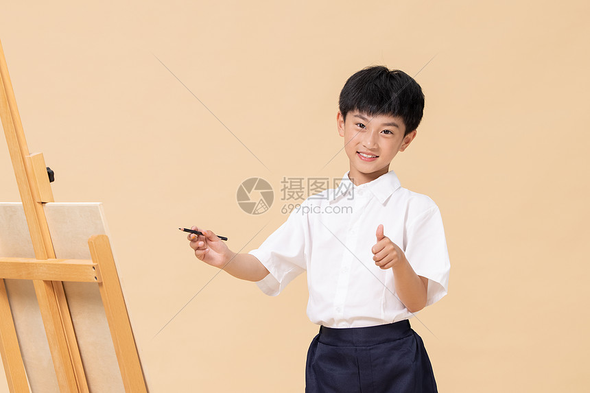 站在画板前绘画的小男孩图片