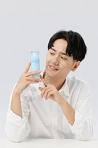 韩系男生手拿瓶装乳液护肤图片