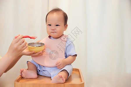 平安果年轻宝妈喂食宝宝吃果泥背景