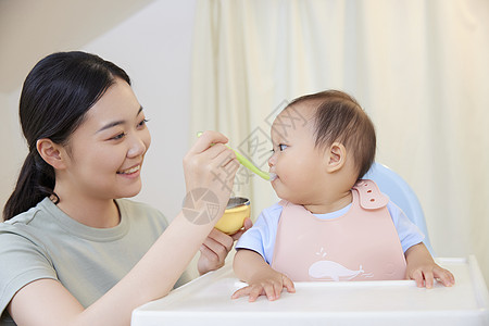 年轻宝妈喂食宝宝吃果泥背景