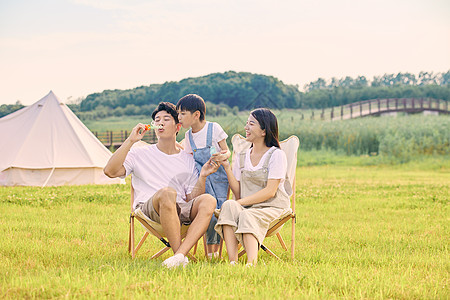 一家三口露营郊游小男孩吹泡泡背景图片