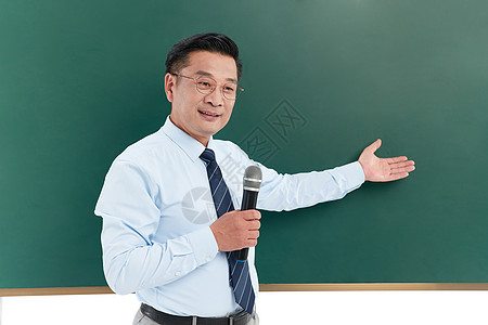 中年教授手举话筒在课堂上演讲图片