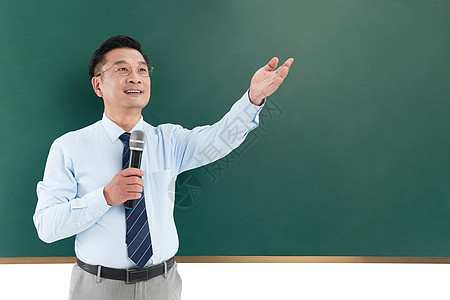 中年教授在黑板前拿着话筒手举向高出图片