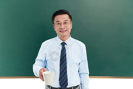 中年教授在黑板前端着水杯图片