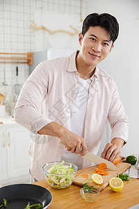年轻男性做饭帅气的年轻男士在厨房切菜背景