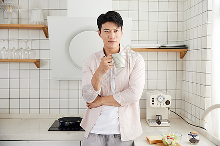 年轻男性做饭帅气的年轻男士在厨房喝咖啡背景