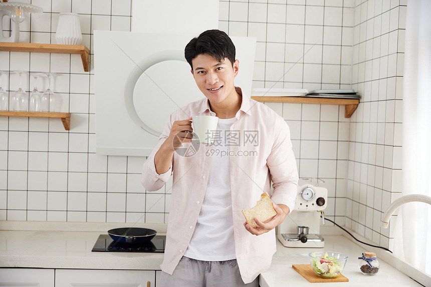 帅气的年轻男士在厨房吃早餐图片