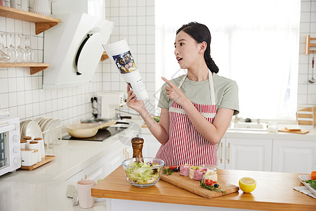 年轻女孩在厨房学做菜图片