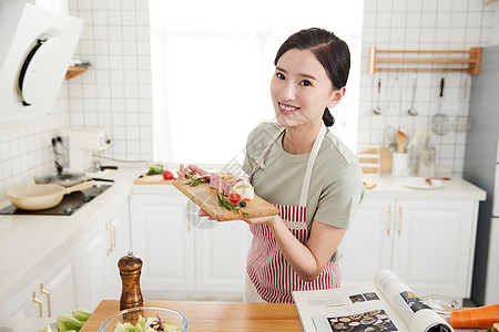 年轻女孩在厨房做早餐图片