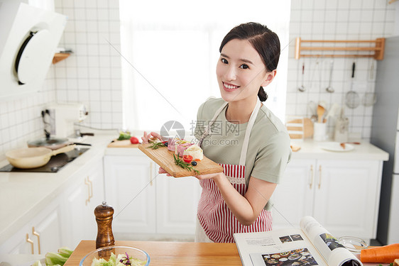 年轻女孩在厨房做早餐图片