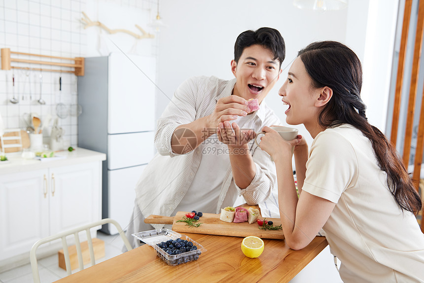 年轻情侣在厨房吃早餐图片