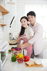 快乐的年轻情侣在厨房里一起做饭图片