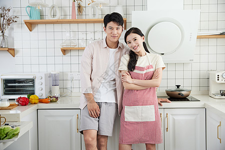 快乐的年轻情侣在厨房里准备做饭图片