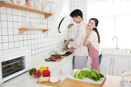 年轻情侣在厨房里做饭图片