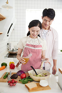 快乐的年轻情侣在厨房里做轻食图片