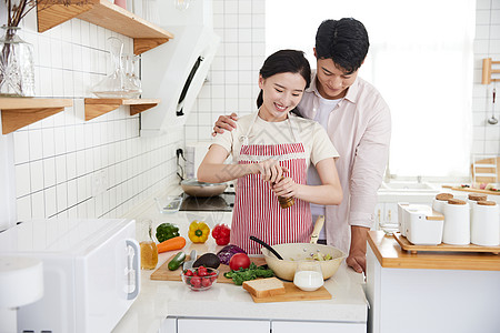 快乐的年轻情侣在厨房里做轻食图片