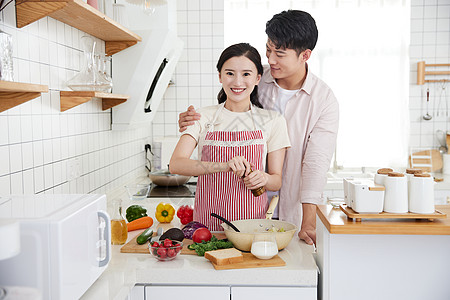 年轻情侣在厨房里烹饪图片