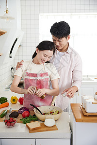 年轻情侣在厨房里烹饪图片