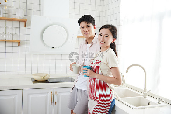 快乐的年轻情侣在厨房里喝咖啡图片