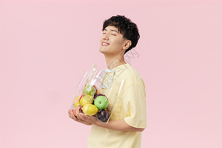青年男性苹果韩系帅哥手抱水果袋侧面背景