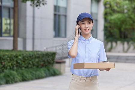 女性快递员打电话配送快递图片